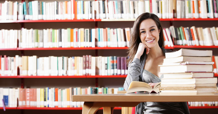 Startseite Pflegestudiengaenge Studentin in einer Bibliothek